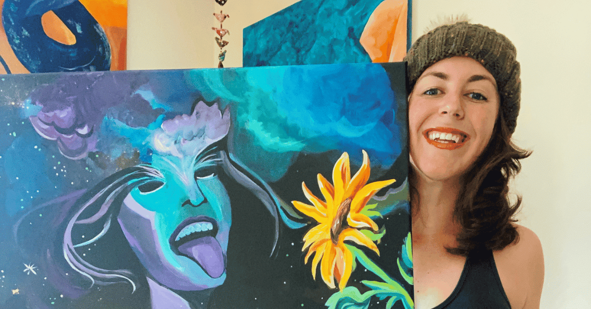 image a of Kate DeCoste smiling beside her painting